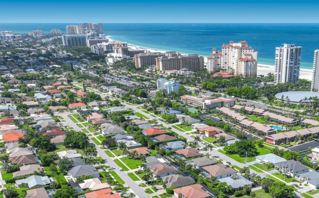 Aerial view of Marco Island homes and coastal high-rises beside the beach and Gulf of Mexico.