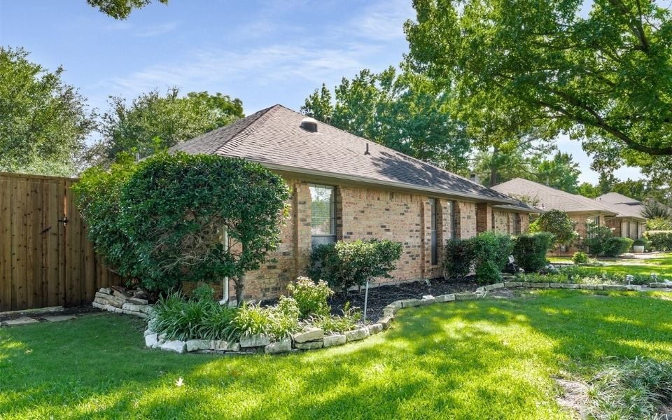 Brick home on sunny day with well-kept lawn in Coppell