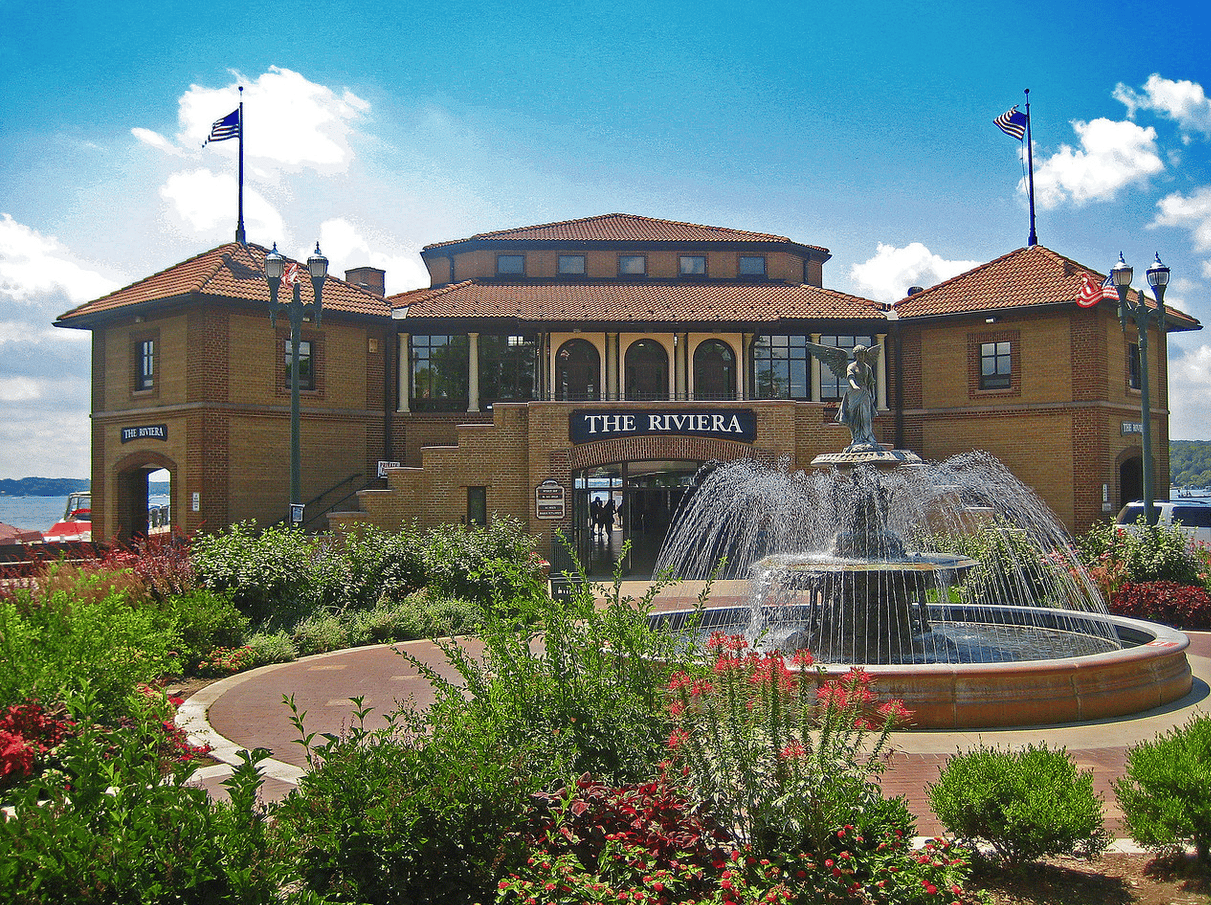 The Riviera building behind a tiered fountain and landscaped flower beds.