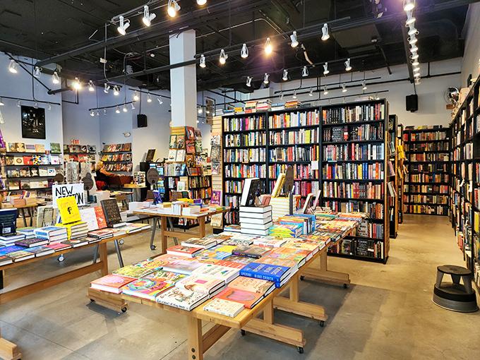 Bookstore interior with tall bookshelves and tables displaying colorful books.