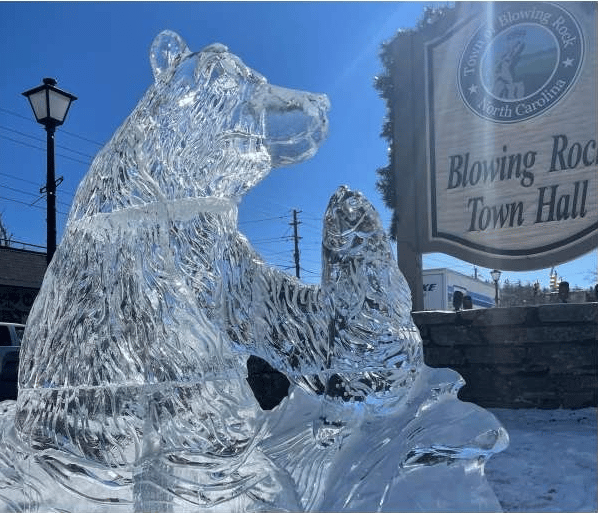 Ice sculpture of a bear beside the Blowing Rock Town Hall sign.