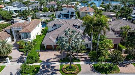 Aerial view of a Boca Raton home with a tiled roof and palm-lined landscaping.