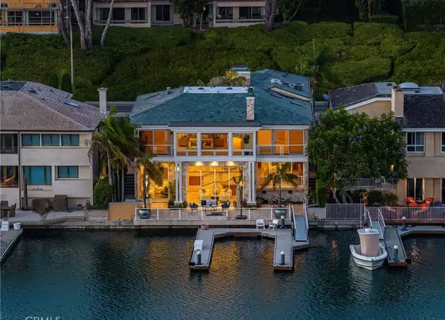 Luxury waterfront home with private dock on Newport Beach harbor at sunset