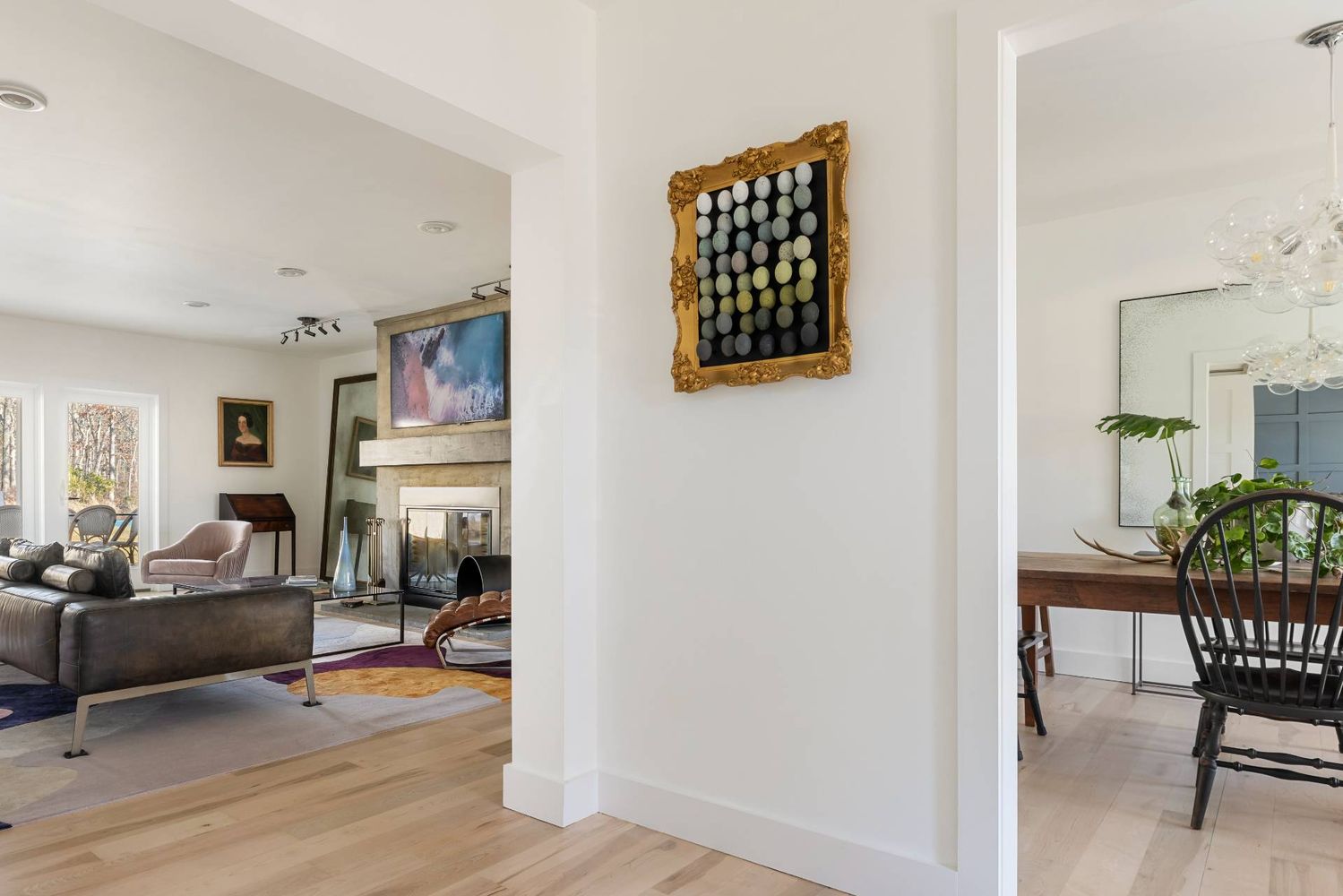 Furnished living room with stone fireplace, colorful rugs, and adjoining dining area.