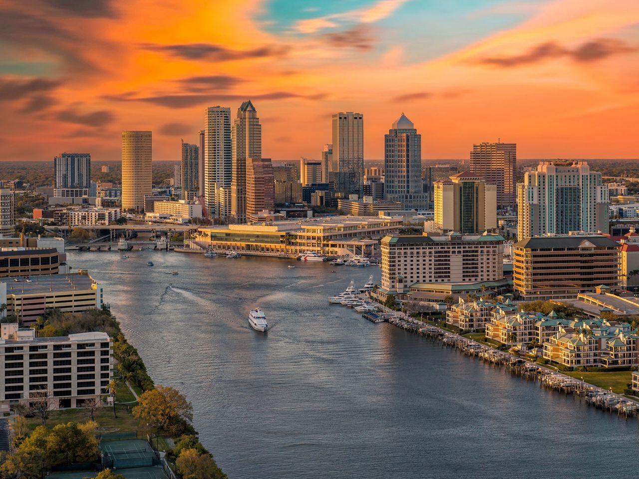 Panoramic sunset over Tampa Bay featuring colorful skies, calm waterfront, and the downtown skyline