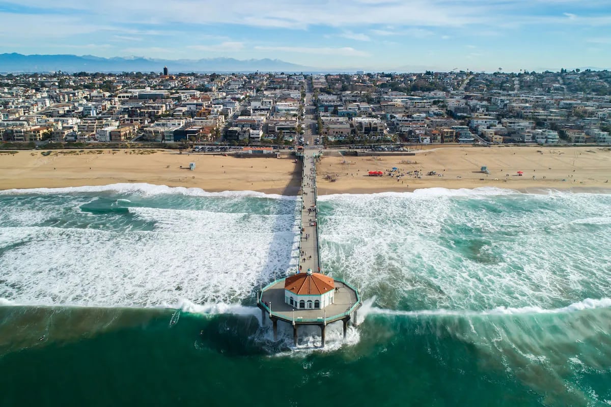 Aerial view of the Manhattan Beach Pier and Roundhouse above the surf in Manhattan Beach