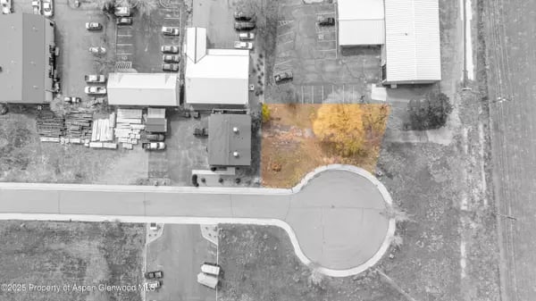 Aerial view of a highlighted tree-covered parcel beside an industrial road and cul-de-sac.