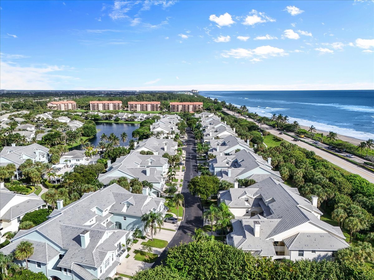 Aerial view of coastal homes beside a lake and ocean shoreline.