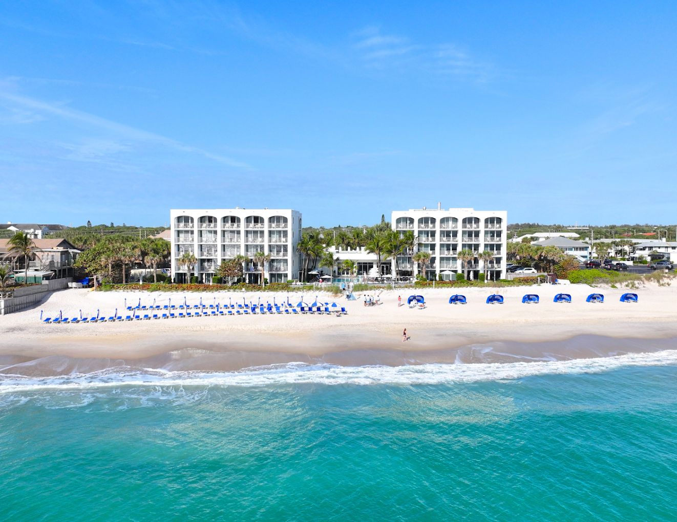 Aerial view of the Vero Beach oceanfront along Ocean Drive, with turquoise Atlantic water, white sand, and low-rise architecture