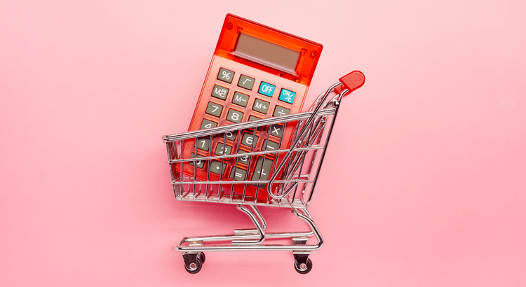 Red calculator inside a shopping cart on a pink background, symbolizing budgeting for HOA fees in homeownership.