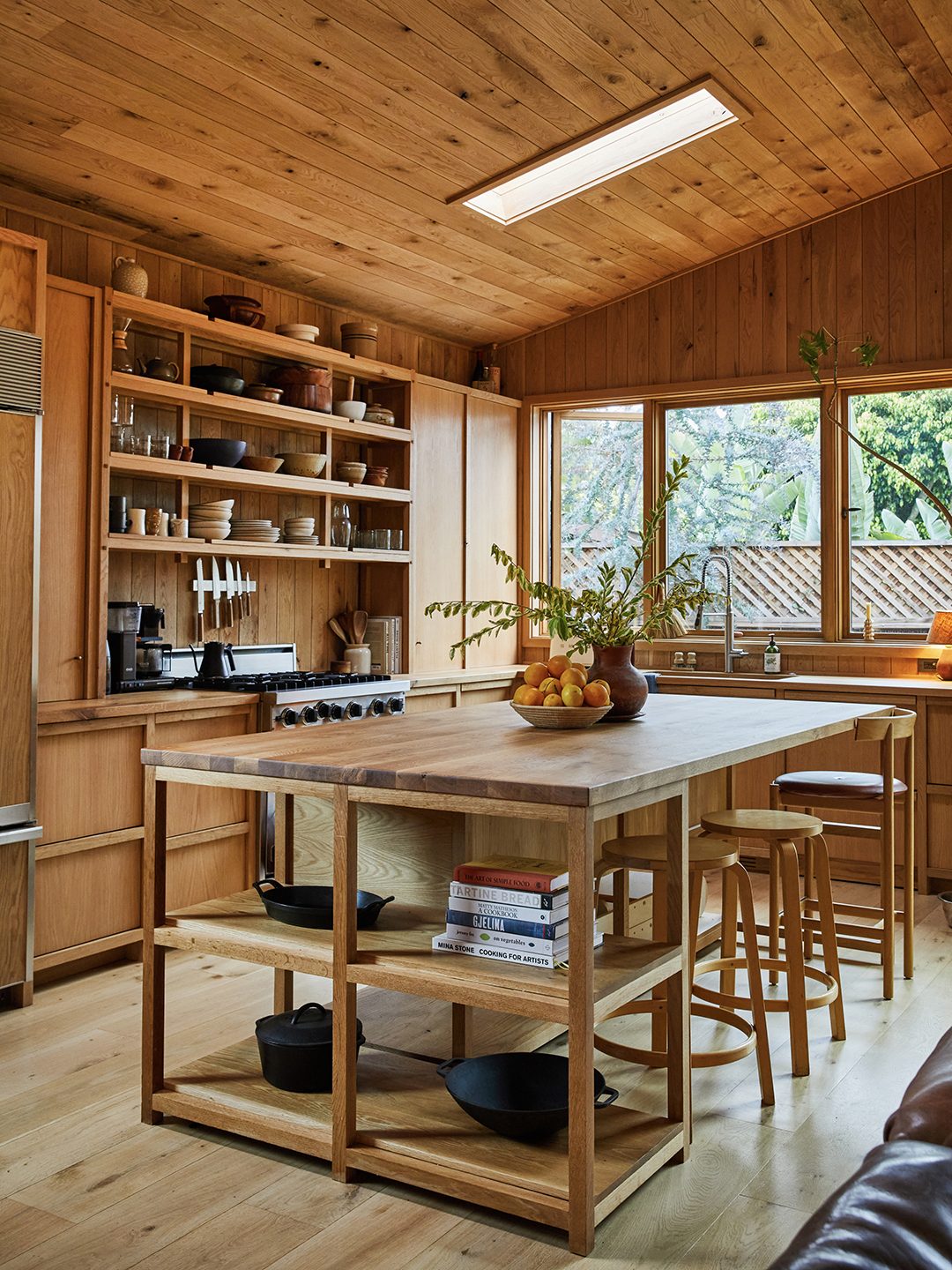 A custom oak kitchen island with open shelving, built by hand to fit the space.