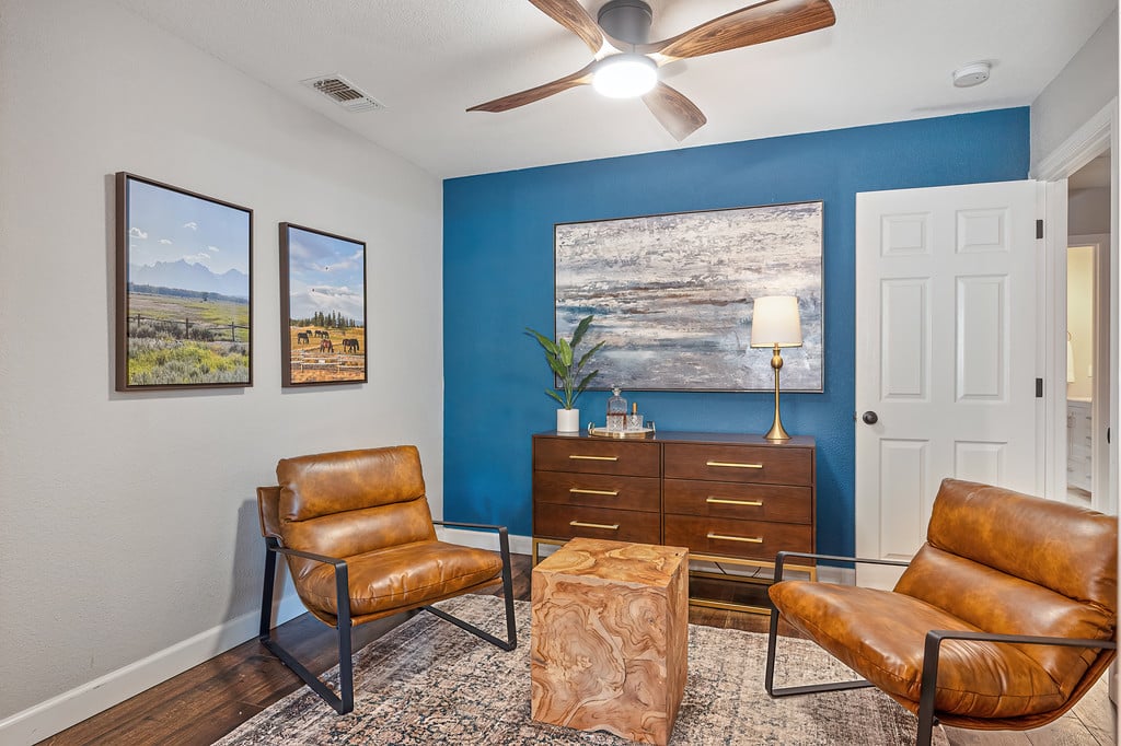 Living room with brown leather chairs, a blue accent wall, and a wood-block coffee table.