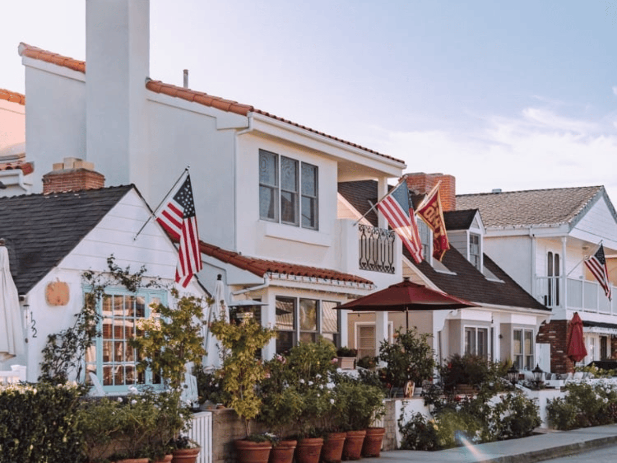Aerial view of luxury waterfront homes and neighborhoods in Newport Beach, California along the harbor and coastline.