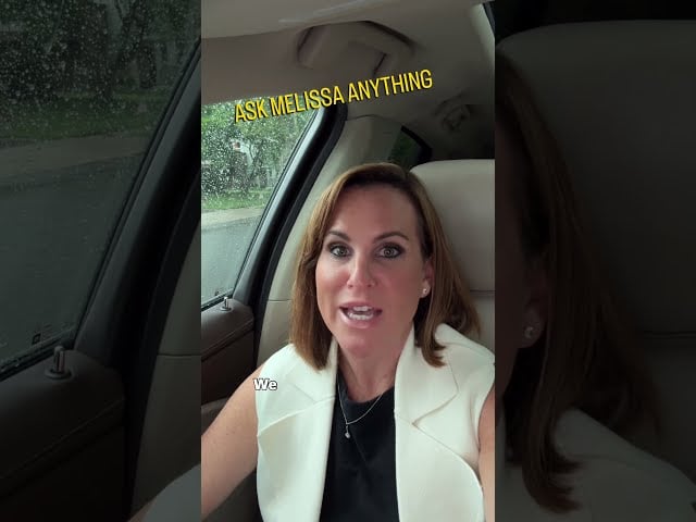 Melissa Infanzon speaking inside a car, wearing a white blazer.