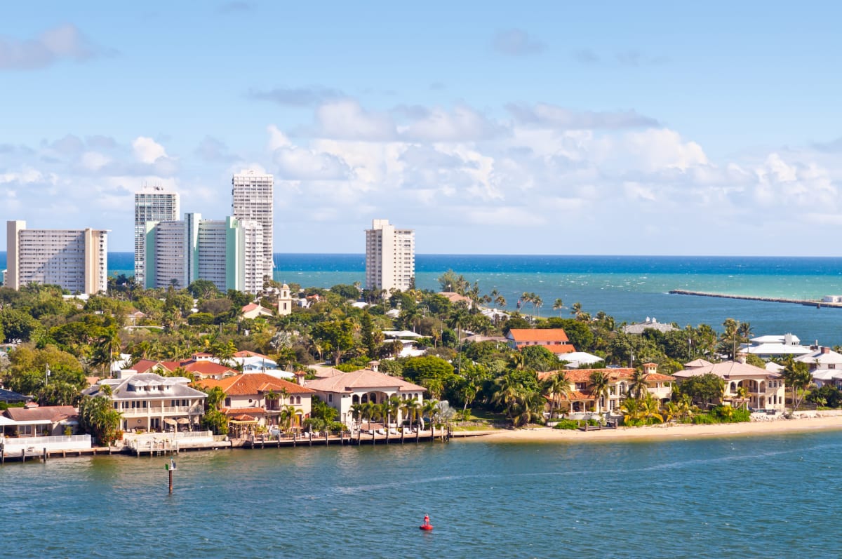 Fort Lauderdale cityscape with tall buildings and houses on a beach next to the ocean