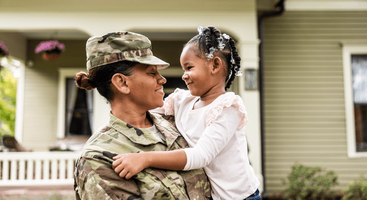 A woman in military uniform gently holds a child, symbolizing strength and nurturing in a moment of connection.