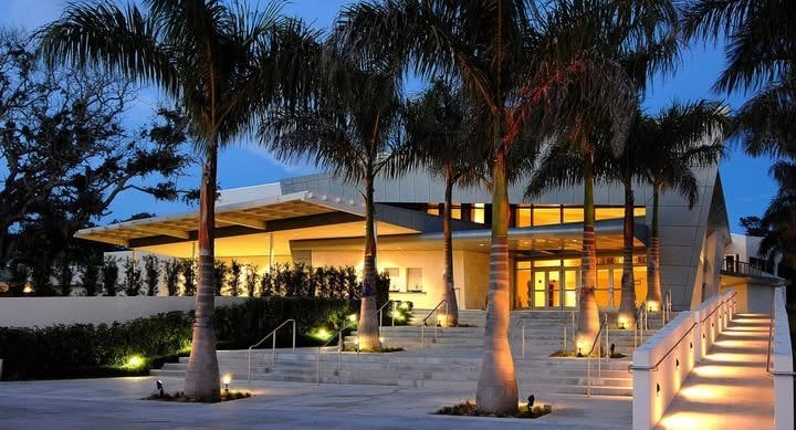 Riverside Theatre in Vero Beach at evening, with royal palms and lit steps at the entrance