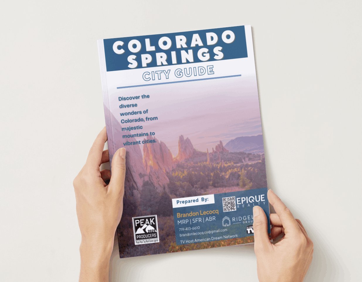 Colorado Springs City Guide booklet showing red rock formations, held in two hands.