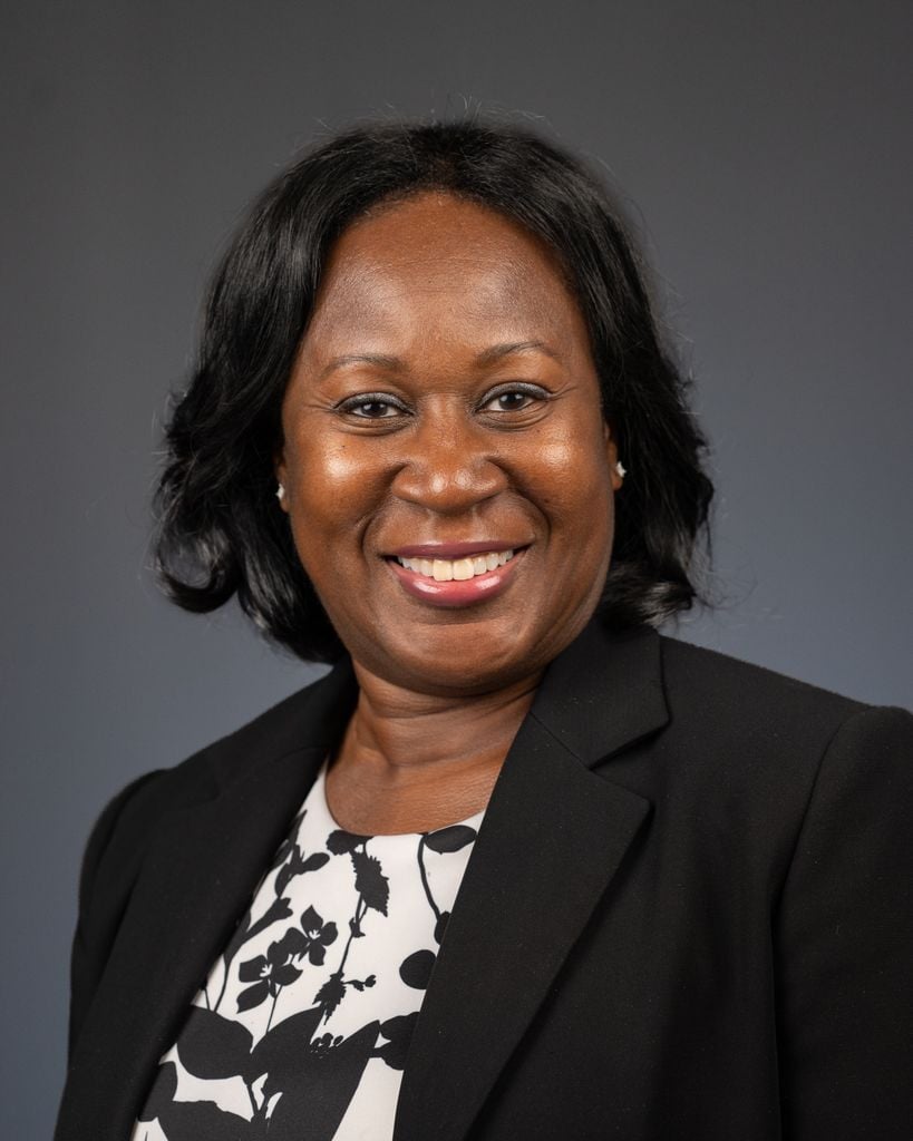 Jennifer McSwain smiling in a black blazer and patterned blouse.