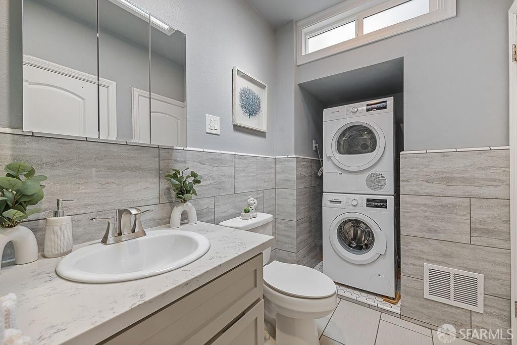 Bathroom with a marble-look vanity and stacked washer and dryer.
