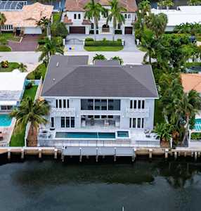 Waterfront home with a backyard pool and dock on a canal, viewed from above.