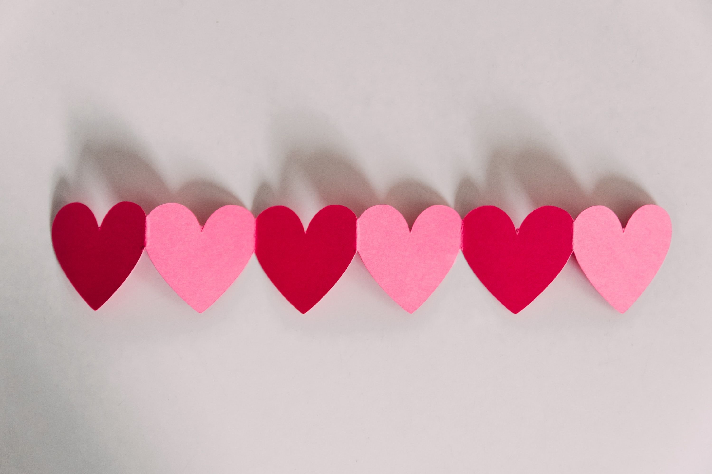 Alternating red and pink paper hearts strung as a Valentine's Day garland.