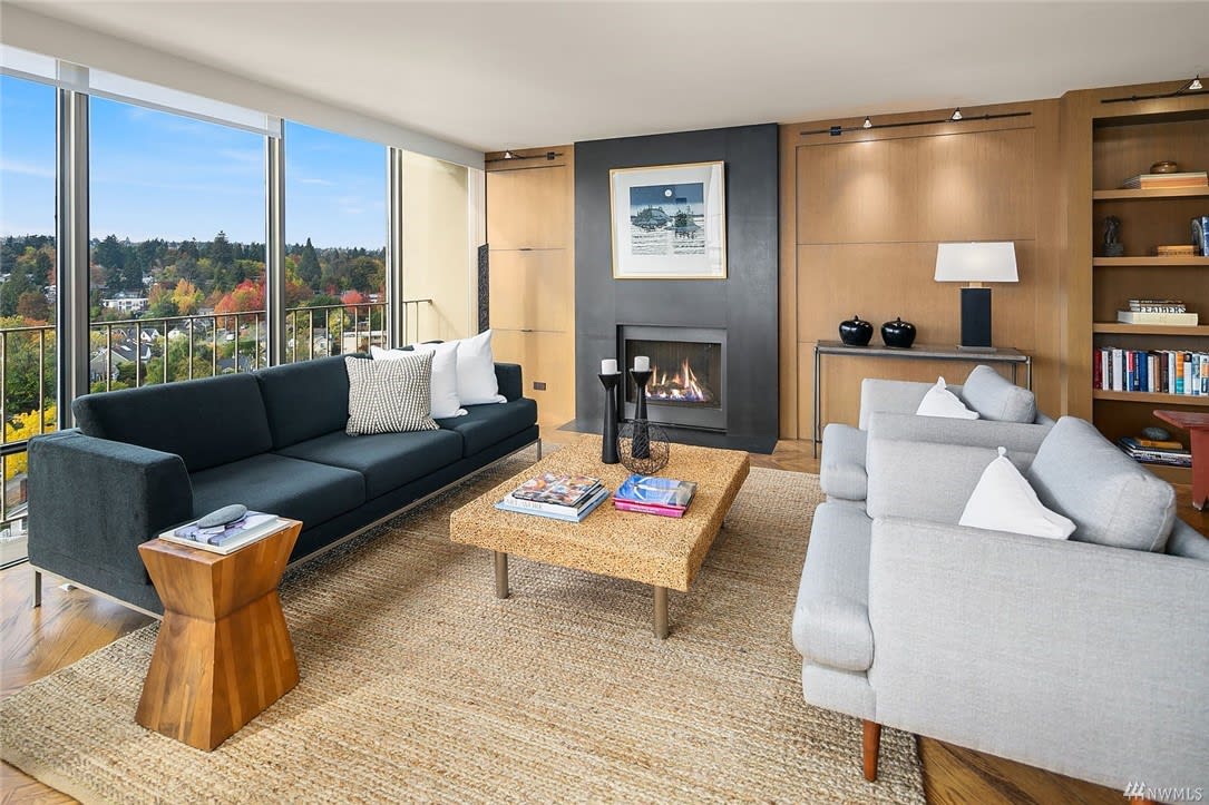 A luxurious condo living room with large windows, offering a warm, inviting atmosphere with neutral tones.