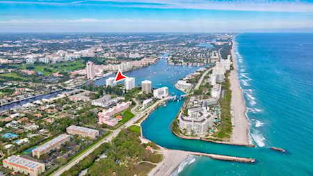 Aerial view of East Boca’s coastline, with beachfront towers, marinas, and waterways beside the Atlantic Ocean.