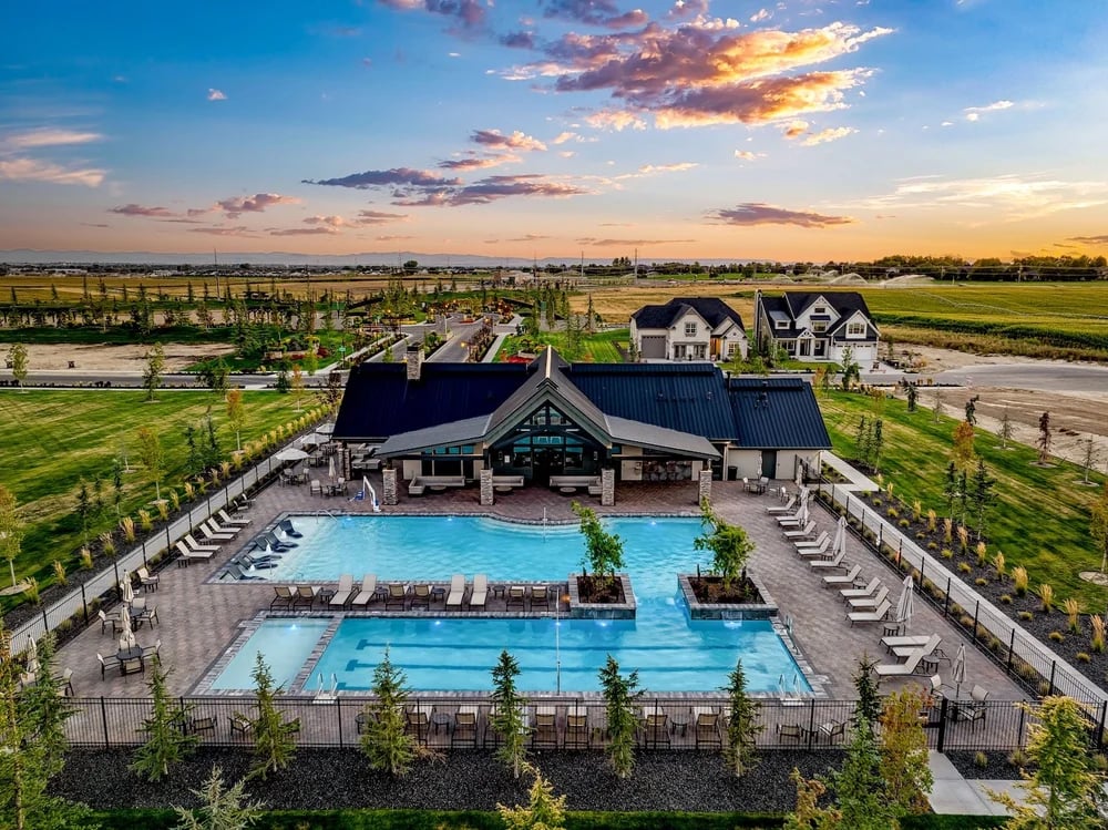 Terra View community pool and clubhouse, with two pools, lounge chairs, and open fields at sunset.