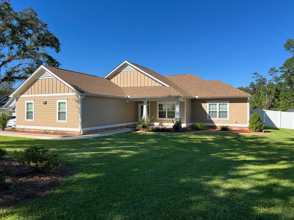 A spacious home surrounded by a large, fenced yard, providing ample outdoor space for relaxation and activities.
