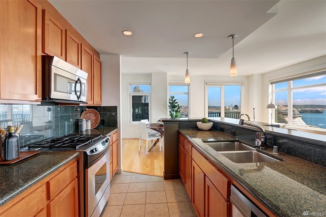 Modern condo kitchen with sleek finishes and a stunning water view, epitomizing luxurious urban living.