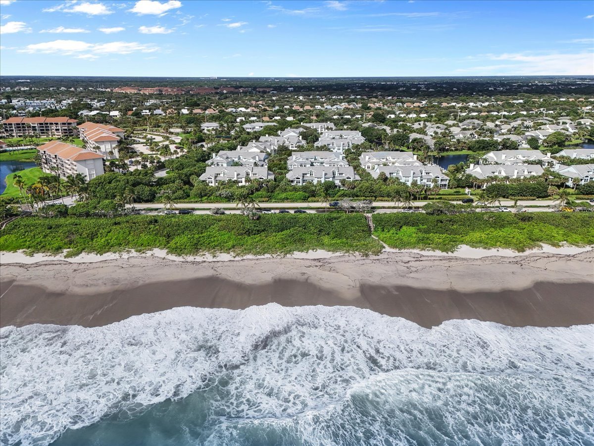 Sea Colony condominiums line the coast behind a beach with ocean surf.