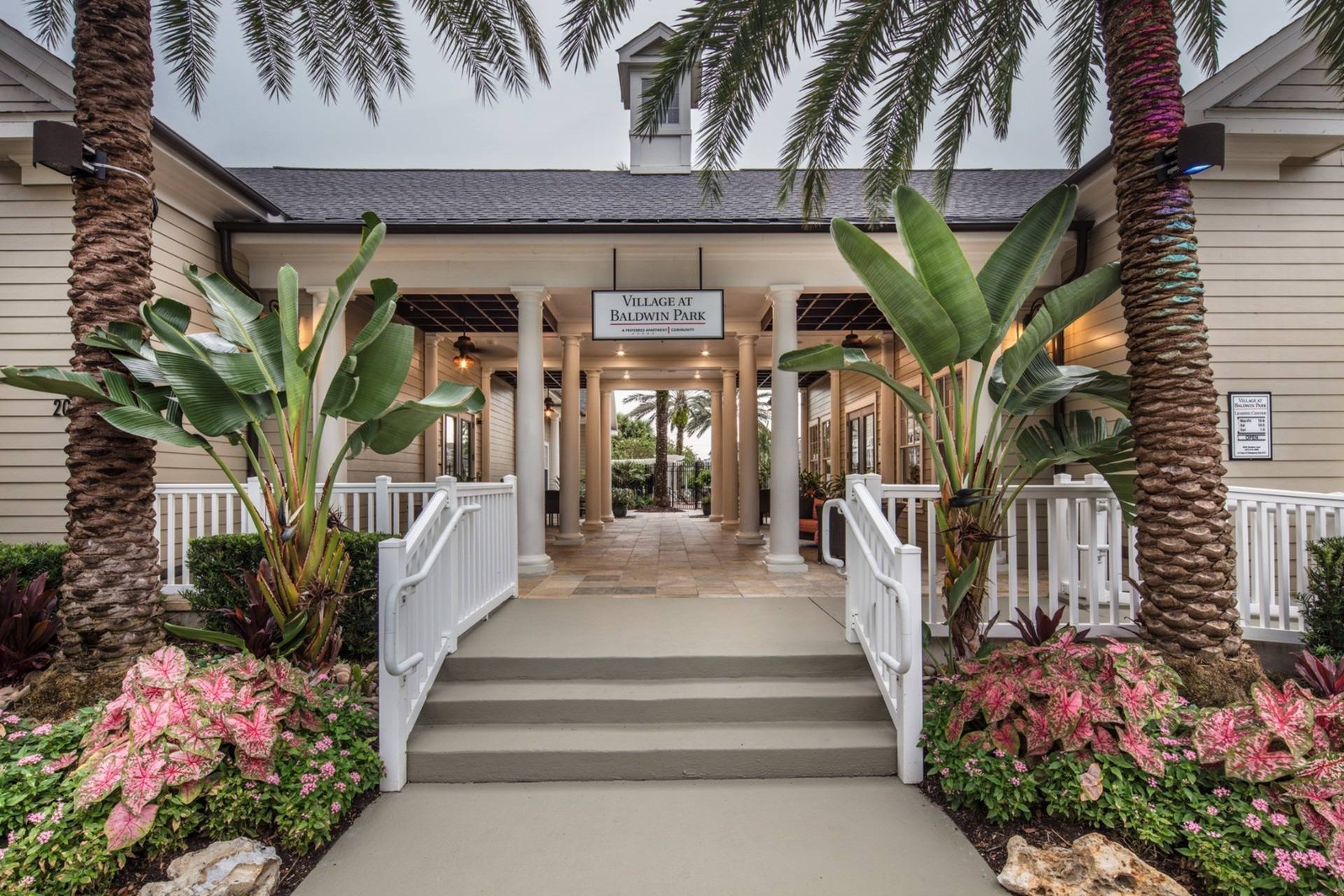 Village at Baldwin Park entrance framed by palm trees and tropical landscaping.