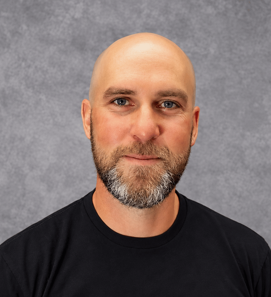 Jake Sklanka, a bald man with a salt-and-pepper beard wearing a black shirt.