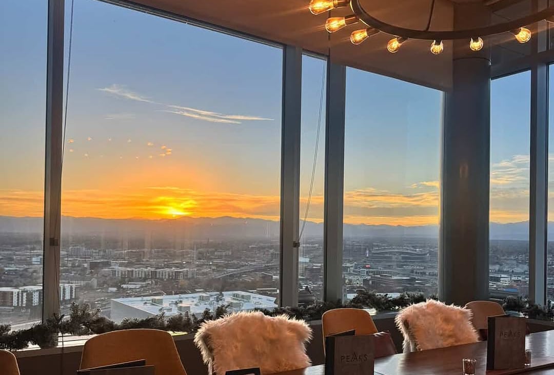 Rooftop dining in Denver with sunset views over the Rocky Mountains and city skyline