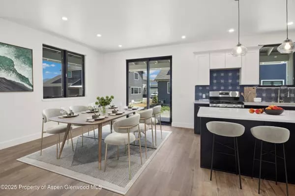 Open-plan kitchen and dining area with a dark island and sliding glass doors.