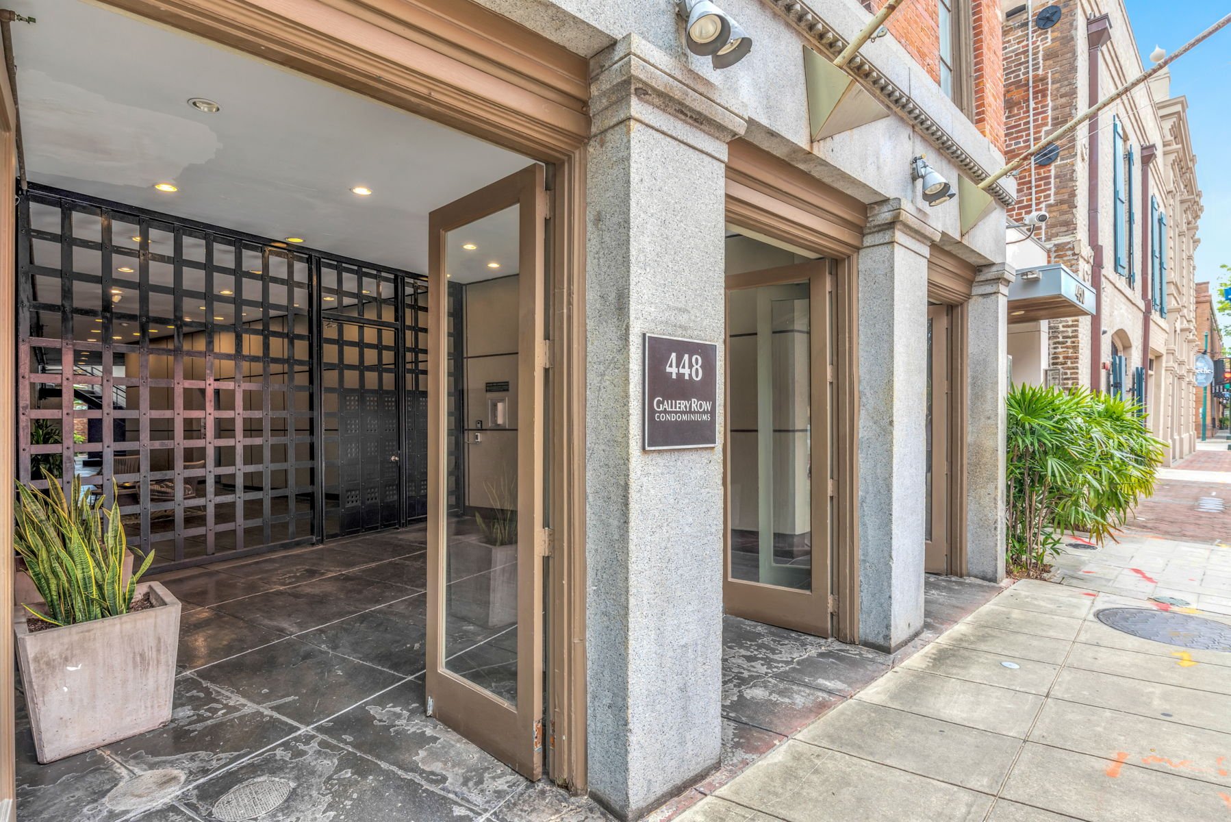 Gallery Row condominiums entrance at 448 Julia Street, with a stone facade and black metal gate.