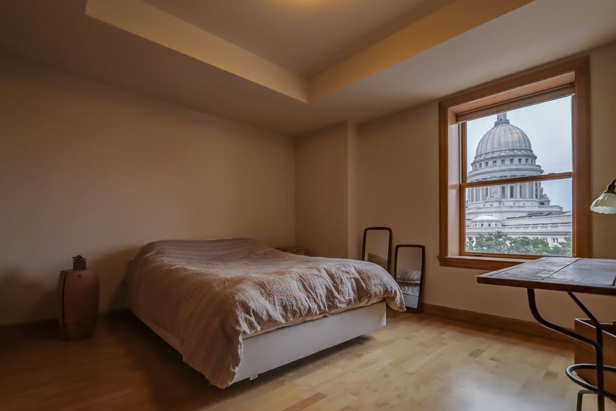 Furnished bedroom with a window overlooking the Wisconsin State Capitol dome.