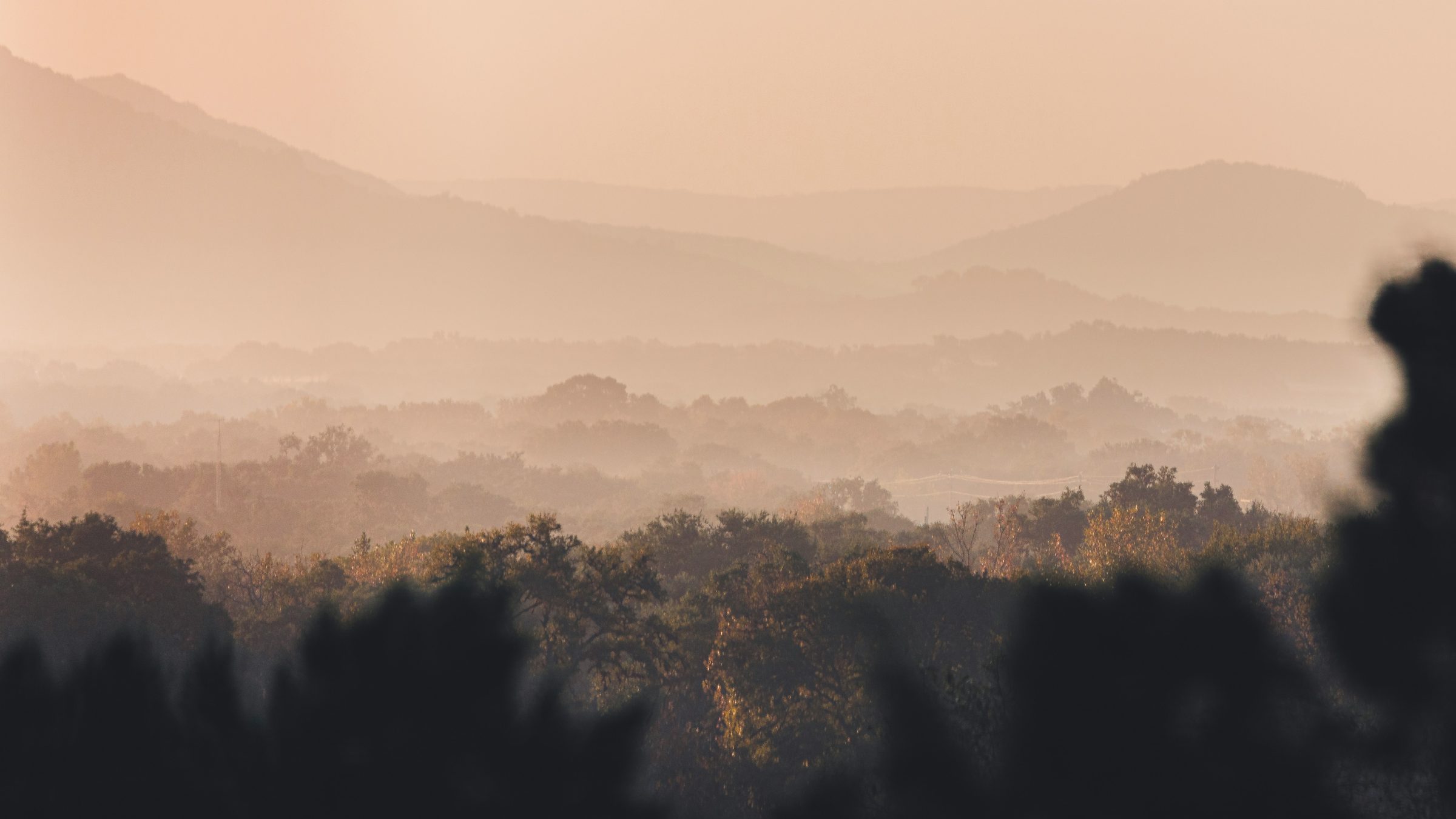 Layered oak-covered ridges in the Texas Hill Country near Vanderpool at dawn.
