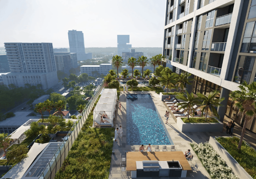 Neo Edgewater’s rooftop pool deck, with palm trees, lounge seating, and Miami buildings in the distance.
