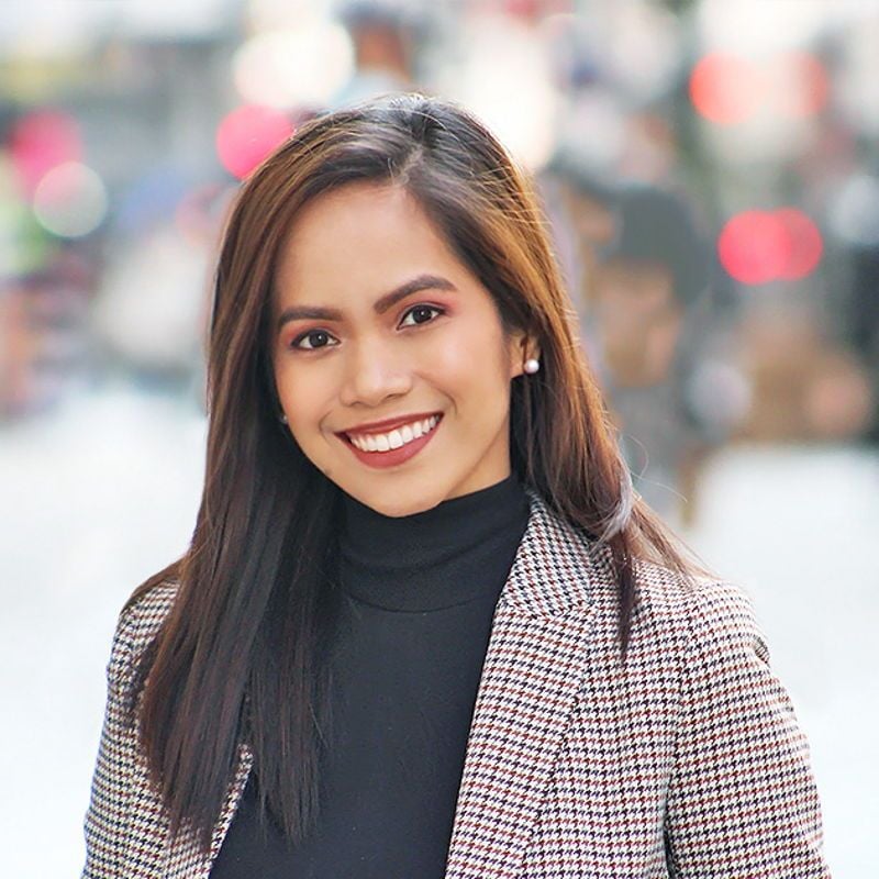Pauline Lou Palestroque smiling in a patterned blazer and black turtleneck.