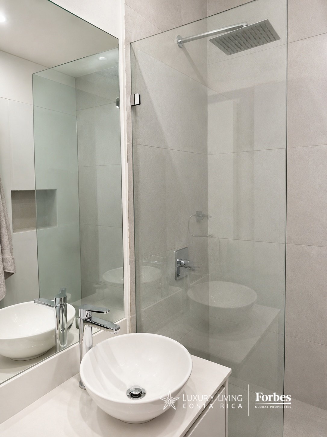 Modern bathroom with a vessel sink and glass-enclosed shower.