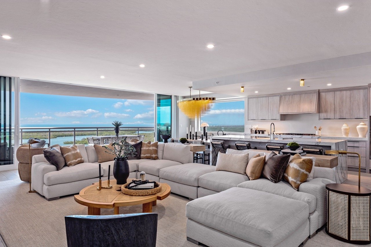 Living room with floor-to-ceiling windows and water views in a Kalea Bay residence