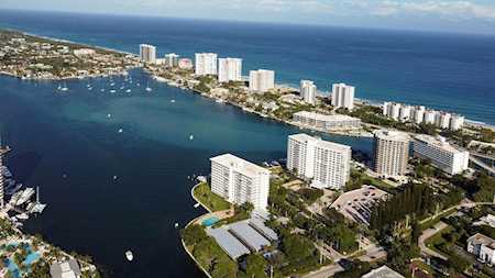 East Boca Raton waterfront high-rises beside a boat-filled inlet and the Atlantic Ocean.