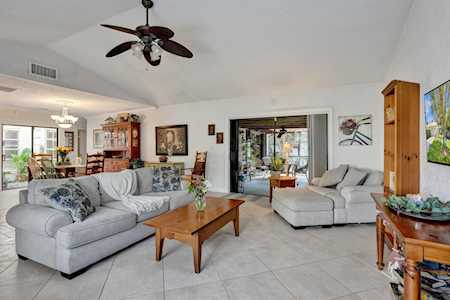 Living room with gray sectional sofas, a vaulted ceiling, and sliding glass doors to an outdoor area.