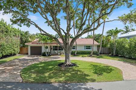 Single-story home with a broad driveway and mature shade tree in the front yard.