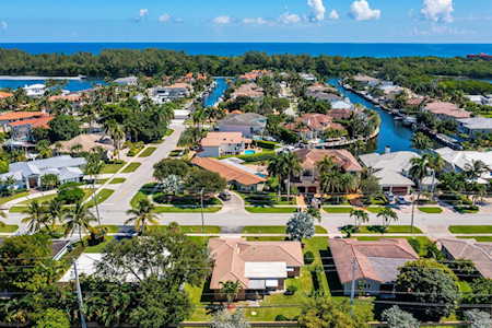 Aerial view of East Boca homes along a canal, with the ocean beyond.