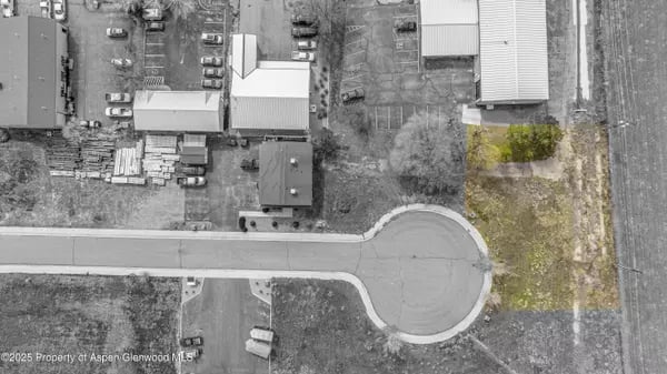 Aerial view of industrial buildings and yards surrounding a paved cul-de-sac.