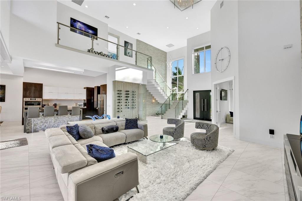 Luxury Cape Coral waterfront home interior with double-height ceilings floating glass staircase and open plan living area