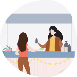 Two women at a home-goods stall with vases, plants, and string lights.